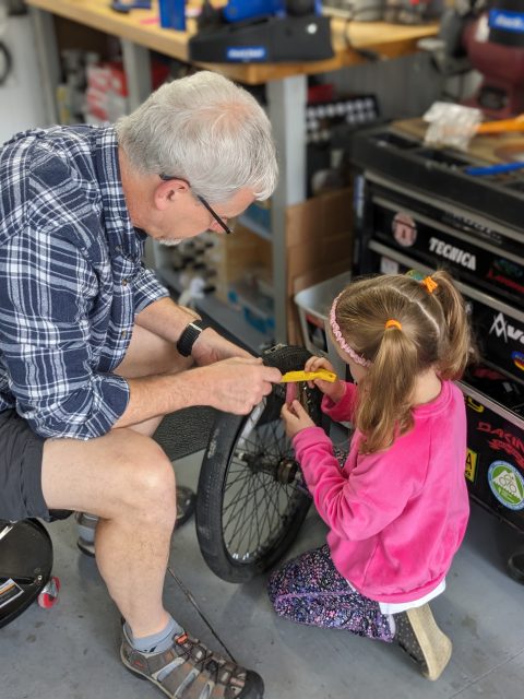 John and his granddaughter working together on a bicycle