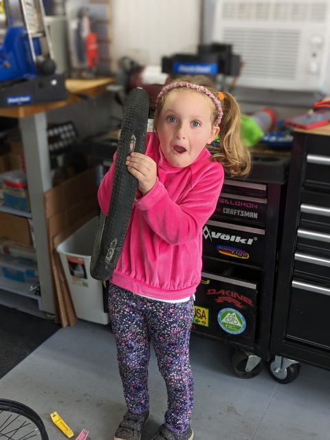 John’s granddaughter holding a bicycle repair tool
